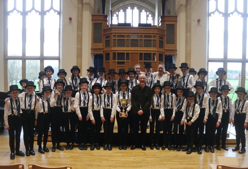 Members of Bax Consort choir pose with composer Bob Chilcott and their trophy after winning the choir competition